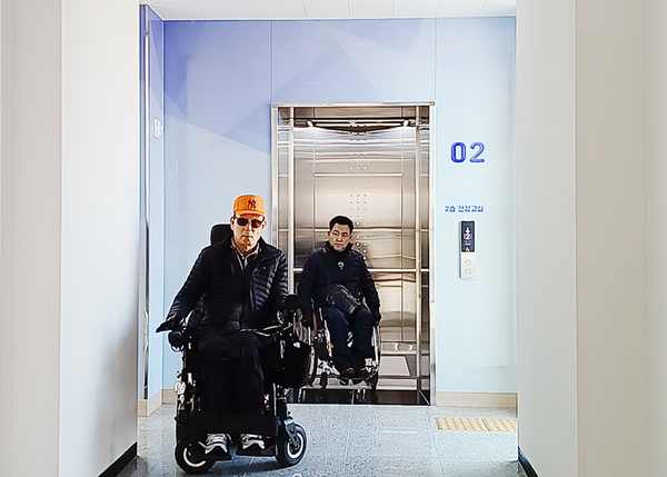 엘리베이터로 여성회관 2층으로 이동하는 조정오 소장(뒤쪽)과 최준식 장애인활동가(앞쪽)