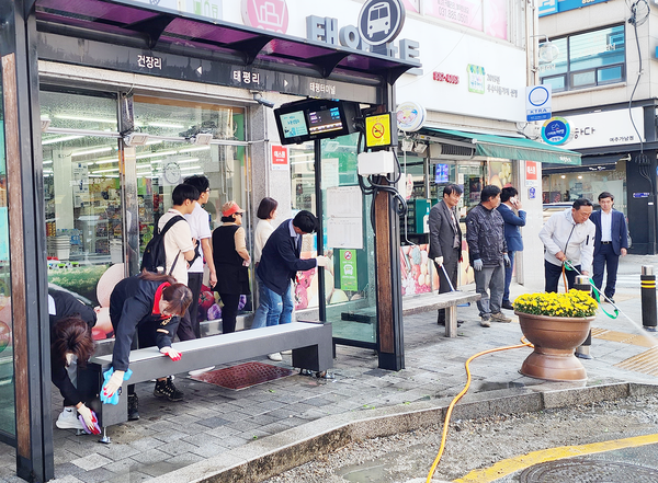 이충우 여주시장(사진 오른쪽 흰색 상의)이 고압세척기로 버스승강 주변을 청소하고 있다.